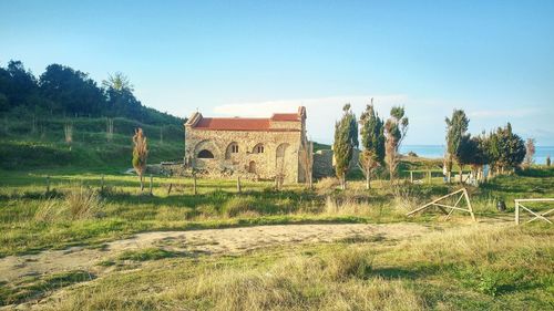 Abandoned built structure on field against clear sky