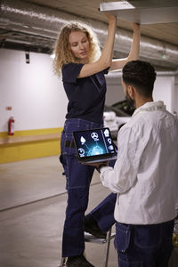 Man and woman checking air duct