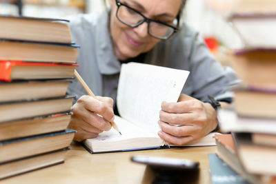 Woman writing in book on table