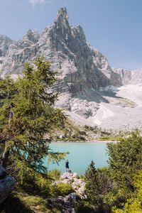 Man standing on the rock overlooking lake sorapis