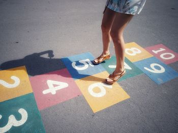 Low section of woman standing on road