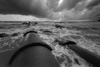 Low section of person on beach against sky