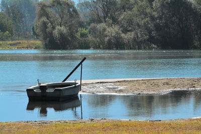 Boat floating on lake against trees