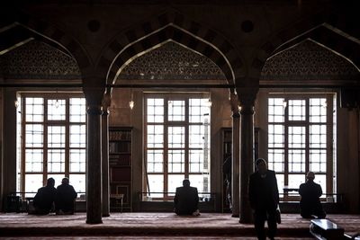 Silhouette people sitting in corridor of building