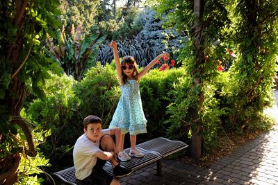 Boy with sister on seat at park