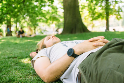 Mid adult man lying on grass in park