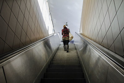 Rear view of woman on steps against sky