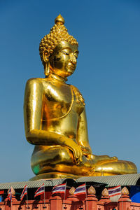 Low angle view of statue against temple against clear sky