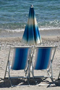 Deck chairs on shore at beach