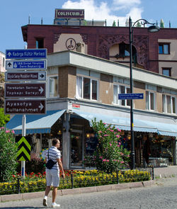 Rear view of woman walking on street against buildings in city