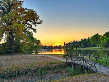 Scenic view of lake against clear sky during sunset