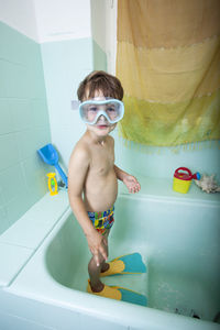 Full length of shirtless boy in bathroom