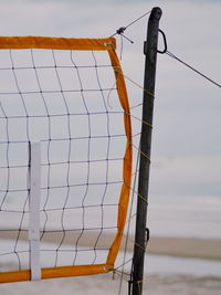 Low angle view of clothesline hanging over sea against sky