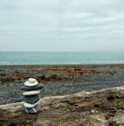Stack of stones on beach against sky