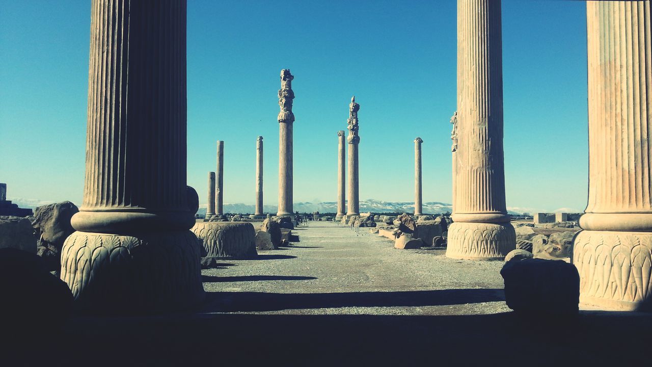 clear sky, architecture, built structure, blue, building exterior, architectural column, column, sunlight, copy space, famous place, travel destinations, in a row, day, history, city, sky, shadow, travel, monument, outdoors