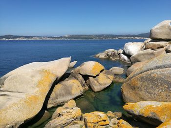 Rock formations on coast against sky