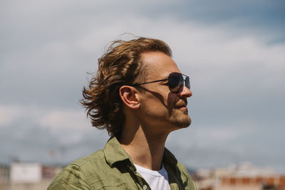 Portrait of young man wearing sunglasses against sky