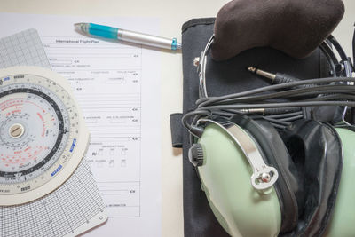 Close-up of headphones with documents on table