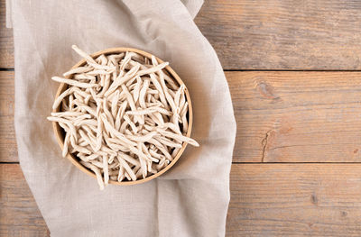 Whole grain wheat apulian pasta pizzarieddi or maccaruni on wooden table. italian pasta background