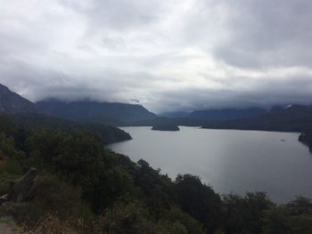 Scenic view of lake and mountains against cloudy sky