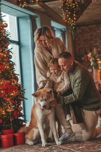 Candid authentic happy family during wintertime together enjoying holidays with dog at xmas