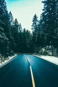 Road amidst trees against clear sky