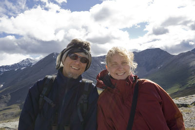 Portrait of young woman with father standing on whistler mountain against sky