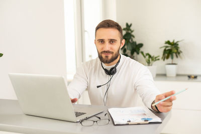 Portrait of doctor using laptop while sitting on table