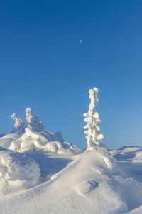 Scenic view of snowcapped mountains against blue sky