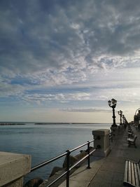 Pier on sea against sky during sunset