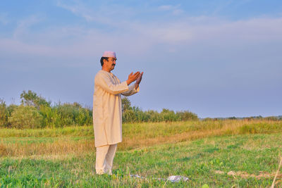 Man standing on field against sky