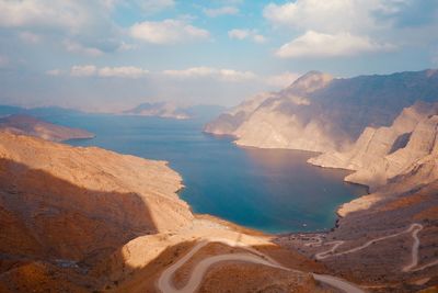 Scenic view of sea and mountains against sky