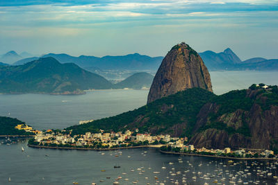 Scenic view of sea and mountains against sky