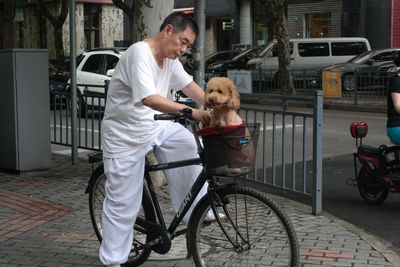 Side view of man with dog on bicycle