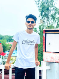 Portrait of young man standing against wall