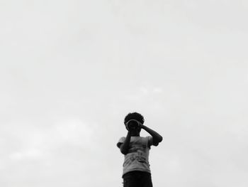 Low angle view of woman standing against sky