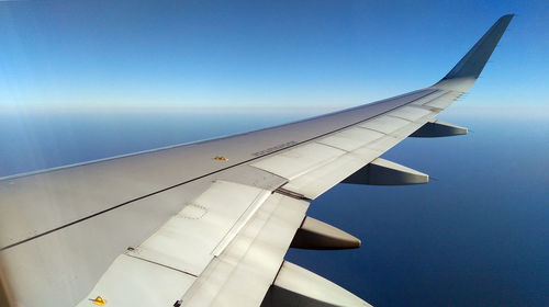 Airplane wing against clear sky