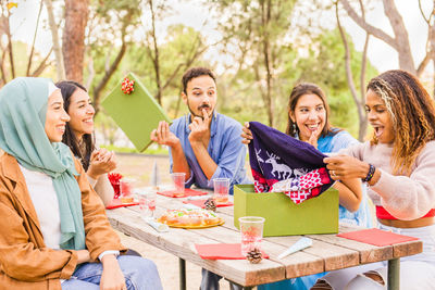 Cheerful friends having food outdoors