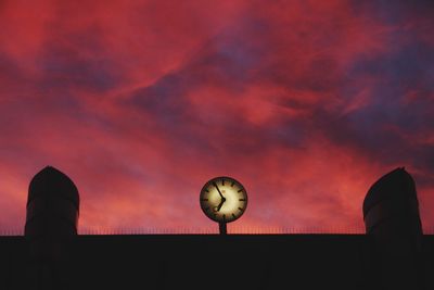 Low angle view of clock against sky during sunset