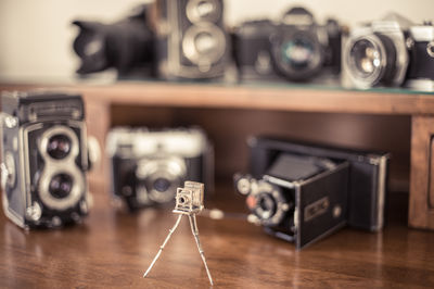 Miniature and old vintage cameras on wooden table