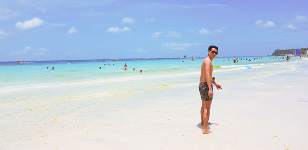 Portrait of shirtless man standing at beach