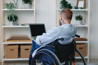 Side view of man using laptop at home