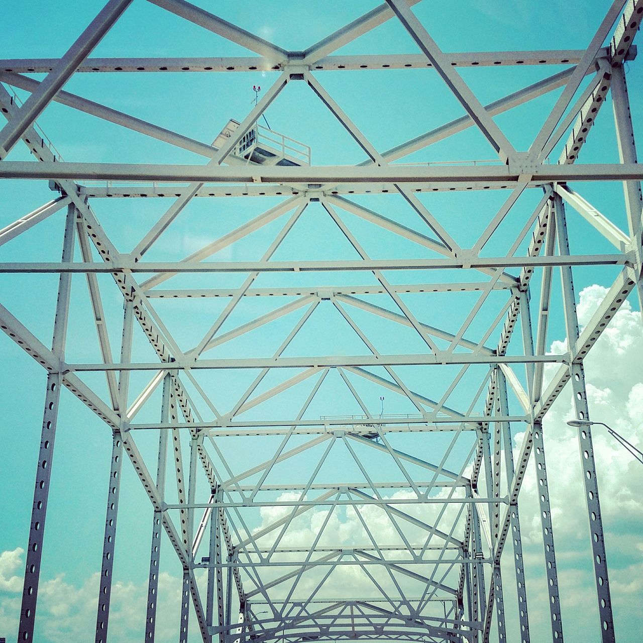 low angle view, connection, metal, sky, electricity pylon, metallic, built structure, power line, day, transportation, outdoors, clear sky, no people, part of, power supply, pattern, cable, electricity, architecture, complexity