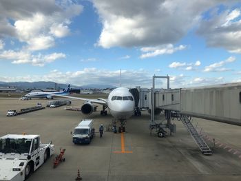 Airplane on airport runway against sky