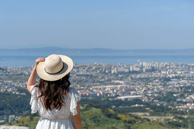 Rear view of woman standing on hill at klis fortress above city of split in croatia