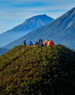 Group of people on mountain range against sky