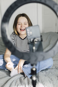 Girl vlogging while sitting on bed