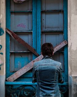 Rear view of man standing against built structure