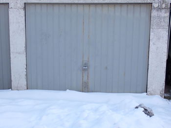 Garage door on snow covered wall of building