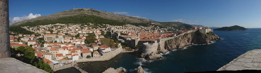 High angle view of townscape by sea against sky